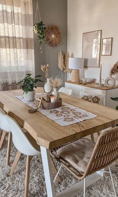 a dining room table with chairs and plants on it