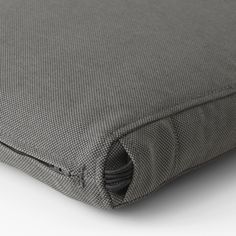 the back side of a bed with grey sheets