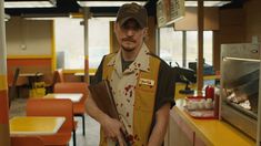 a man in an apron holding a knife and wearing a hat with blood all over it