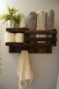 some towels are hanging on a wooden shelf