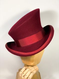 * Stunning asymmetric top hat from wool felt, stiffened and hand blocked over millinery wooden hat blocks. * ENTIRELY HANDSEWN. It is an artisan product, completely handmade,none of the pieces I make is absolutely identical to another. Made to order. I personally design and handcraft each headpiece with care and great attention to detail. * Crown height: 14 cm the highest part and 8 cm the lower part. Brim width 6,5 cm, entire brim proportions: 30 x 26 cm. The brim's edge is wired to keep the sh Red Formal Hat For Winter, Formal Winter Red Felt Hat, Red Fitted Vintage Top Hat, Red Formal Winter Hat, Winter Formal Red Hat, Red Brimmed Top Hat For Winter, Red Fitted Felt Hat For Formal Occasions, Formal Red Fitted Felt Hat, Classic Fitted Burgundy Hat