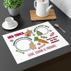 a table with some food on it next to a potted plant and coffee mug