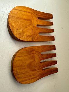 two wooden utensils sitting next to each other