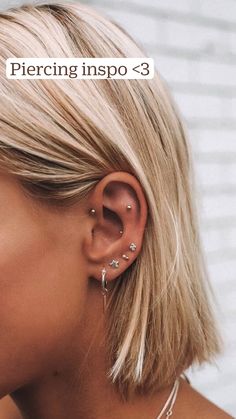 a woman with blonde hair wearing ear piercings