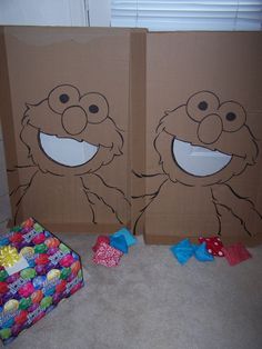 two brown bags with faces drawn on them sitting next to a box filled with candy