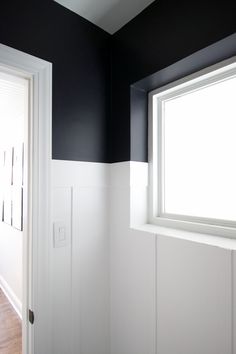 an empty room with black walls and white trim