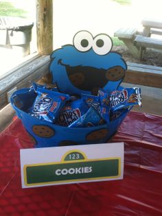 the cookie monster is sitting on top of a table with some candy bars in it