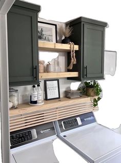 a washer and dryer sitting next to each other in front of some cabinets