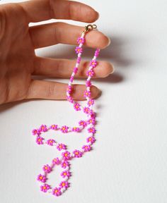 "A dainty pink and white floral necklace. This necklace is made by stitching together tiny, glass seed beads using a needle and thread in a technique known as bead weaving.  The cerise pink flowers have opaque yellow centres and are flanked by opaque white spacer beads.   This beaded necklace is lightweight and comfortable to wear.  The beads, whilst glass, are tough and unlikely to become damaged during normal use. Approximate length of this necklace is 20\". Finished with your choice of clasp! Flower Shaped Beaded Necklaces For Jewelry Making, Pink Beaded Necklace With Tiny Beads For Gift, Dainty Pink Beaded Necklaces For Gifts, Dainty Pink Beaded Necklace For Gift, Pink Tiny Beads Necklace For Jewelry Making, White Flower Necklace With Tiny Beads For Gift, Dainty Pink Beaded Necklaces With Colorful Beads, Dainty Pink Beaded Necklace With Tiny Beads, Delicate Pink Jewelry With Colorful Beads