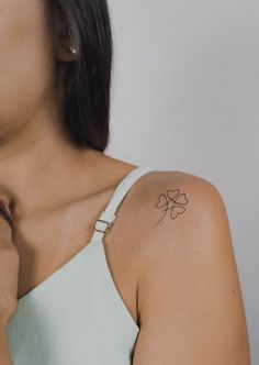 a woman with a small clover tattoo on her left upper arm and right lower arm