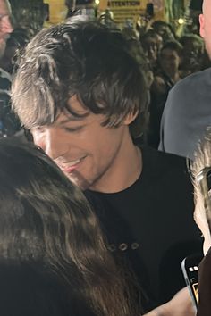 a man in black shirt surrounded by people