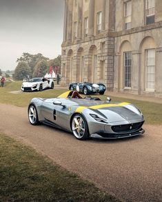 two sports cars parked in front of a large building