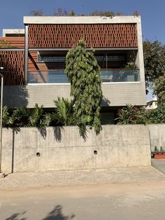 an apartment building with brick and concrete facade, surrounded by greenery on both sides