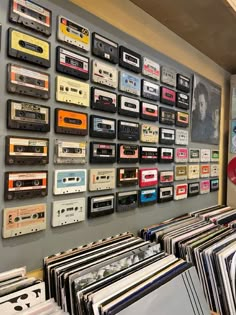 there is a wall full of cassettes and records on the wall in this room