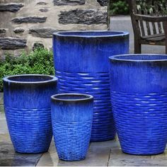 four blue planters sitting next to each other on a patio