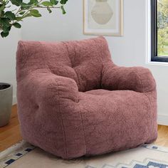 a large bean bag chair sitting on top of a rug next to a potted plant