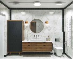 a bathroom with marble walls and flooring, two mirrors on the wall above the sink