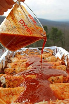 someone pouring sauce on top of some food