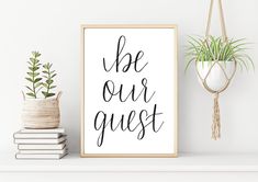 a poster with the words be our guest on it next to a potted plant