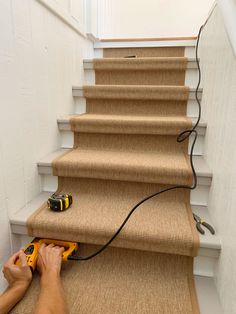 a man using a cordless drill to install carpet on the stairs