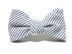 a bow tie that is on top of a white surface with black and white stripes