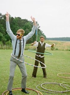 two men are playing with hula hoop in the grass