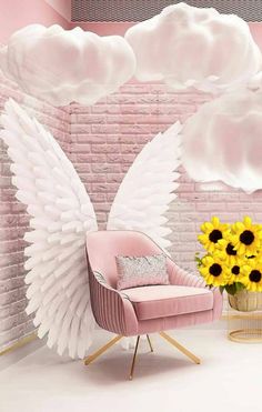 a pink chair with white wings and sunflowers in front of a brick wall