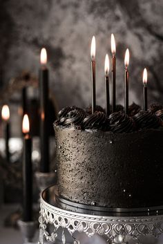 a black cake with candles on top of it