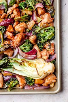 chicken and broccoli stir fry in a baking pan on a white counter top