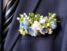 a man wearing a blue suit and tie with flowers on his lapel flower pin