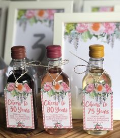 three bottles of alcohol sitting on top of a wooden table next to a framed photo