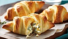 several croissants with cheese and spinach on a plate