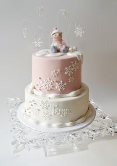 a pink and white cake with snowflakes on it