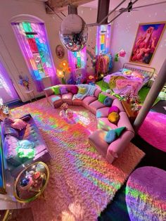 a living room filled with lots of furniture and colorful lights on the walls above it