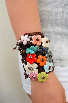 a woman wearing a bracelet with flowers on it