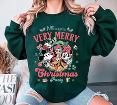 a woman wearing mickey and minnie merry christmas sweatshirt