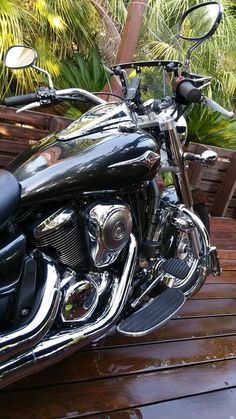 a black motorcycle parked on top of a wooden deck