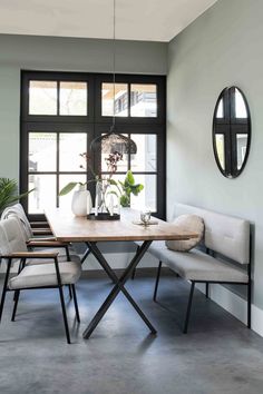 a dining room table with chairs and a bench