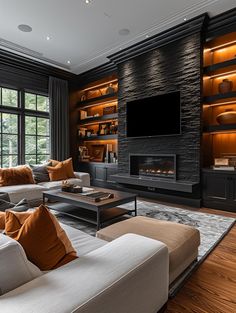 a living room with couches and a television on the wall in front of a fireplace