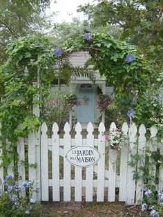 a white picket fence surrounded by flowers and greenery with the name jardin de maison on it