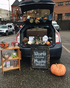 the trunk of a car is filled with halloween decorations and other items, including a sign that reads wizard's welcome muggles to witches