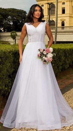 a woman in a white wedding dress posing for the camera