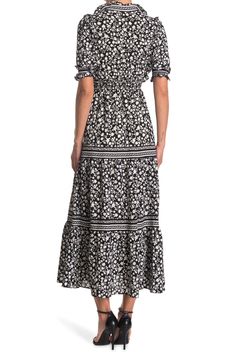 Add this smocked sleeve printed dress to your chic closet completing a stylish ensemble.Fit: this style fits true to size. - Split mock neck with ruffle detailing- Elbow length sleeves with smocked details- Smocked waist- Allover print- Tiered skirt- Maxi length- Approx. 53" length (size S)- Imported Machine wash cold 96% polyester, 4% spandex Black Tiered Dress For Spring Vacation, Casual Fitted Tiered Maxi Dress, Fitted Casual Maxi Length Tiered Dress, Fitted Casual Tiered Maxi Dress, Casual Tiered Maxi Dress In Rayon, Casual Maxi Length Tiered Dress With Smocked Bodice, Casual Tiered Rayon Maxi Dress, Spring Maxi Dress With Elastic Neckline And Tiered Shape, Casual Tiered Maxi Dress With Elastic Waistband