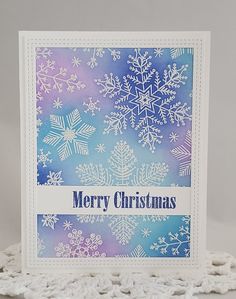 a card with snowflakes on it and merry christmas written in blue, purple and white