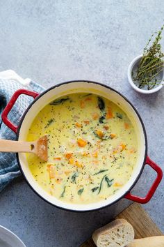 a red pot filled with soup next to bread