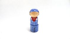 a small wooden figurine wearing a blue and white striped suit