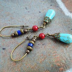 "I made these gorgeous earrings by combining genuine Lapis Lazuli heishi beads in deep blue with occasional glimmers of Golden Pyrite, Red Coral round beads, and Magnesite teardrops in blue-green teal color with brown veins, which is a very popular and economical alternative to genuine Turquoise. I have also added some antiqued brass caps and beads to embellish the stones, and attached them to antiqued brass kidney shaped ear-wires. All metal materials are lead-safe solid brass. Very stylish! Le Bohemian Blue Beaded Earrings With Natural Stones, Blue Southwestern Earrings With Natural Stones, Southwestern Blue Earrings With Natural Stones, Kidney Wire Earrings, Bohemian Style Jewelry, Earring Ideas, Red Gemstones, Handmade Beaded Jewelry, Matching Jewelry