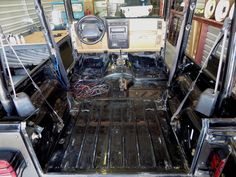 the interior of a vehicle with its doors open and wires in place on the floor