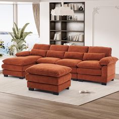 a living room with an orange sectional couch and footstool in front of a bookcase