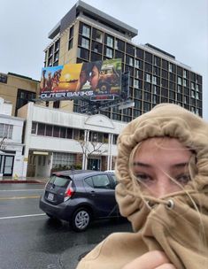 a woman is covering her face with a scarf